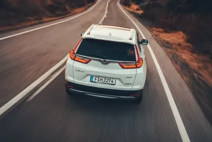 rear view of a honda cr-v driving on a country road