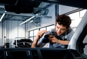 man fixing a windscreen chip from inside a car