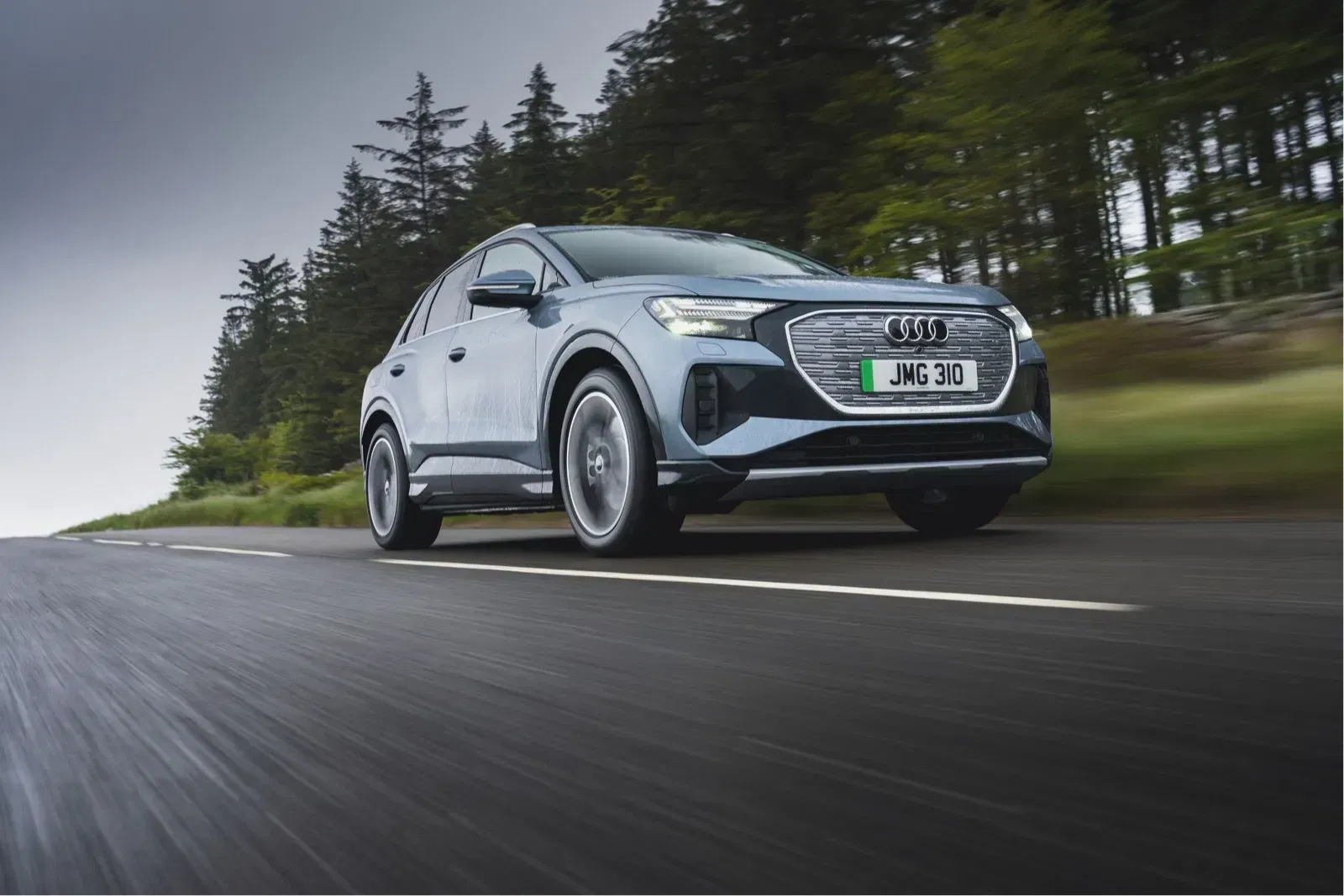 Grey Audi Q4 e-tron driving on wet road