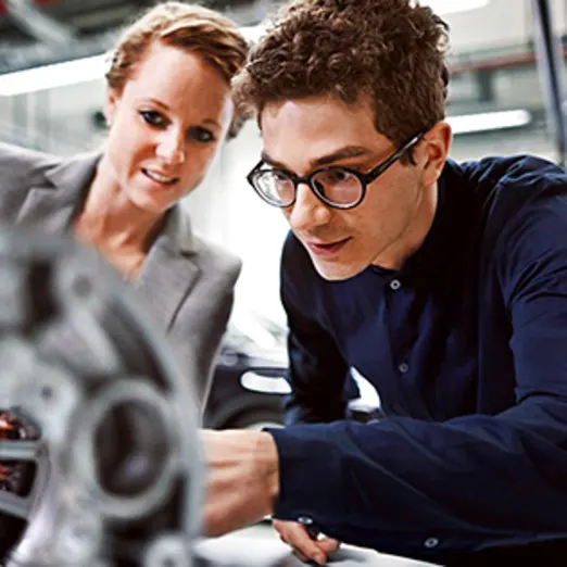 Apprentice inspecting a car component