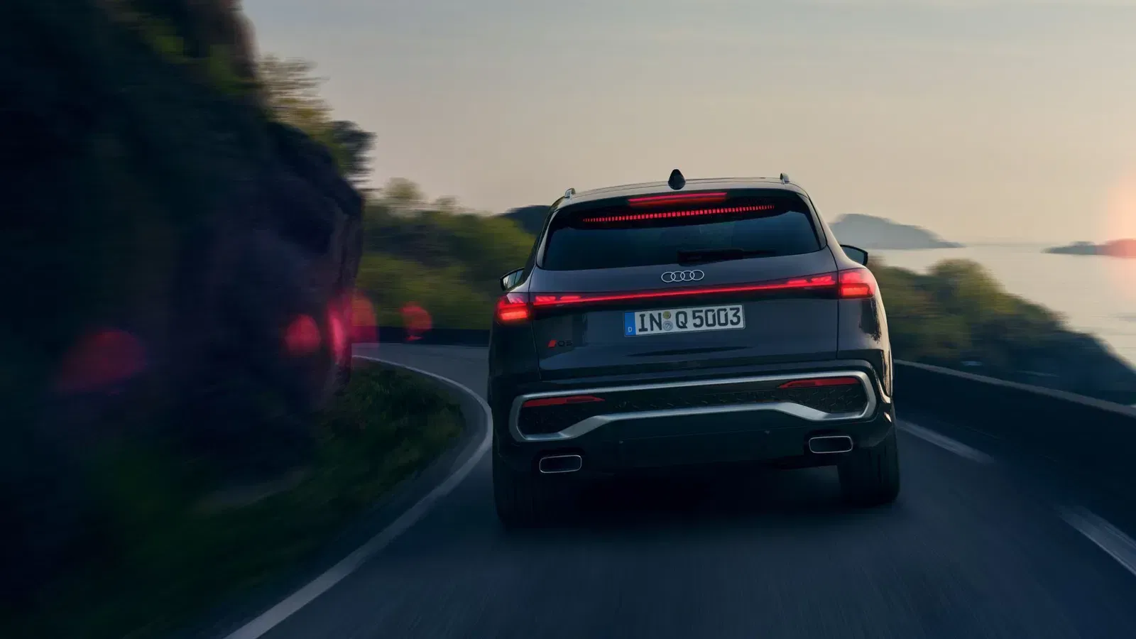 Rear view of Audi SUV driving on windy road