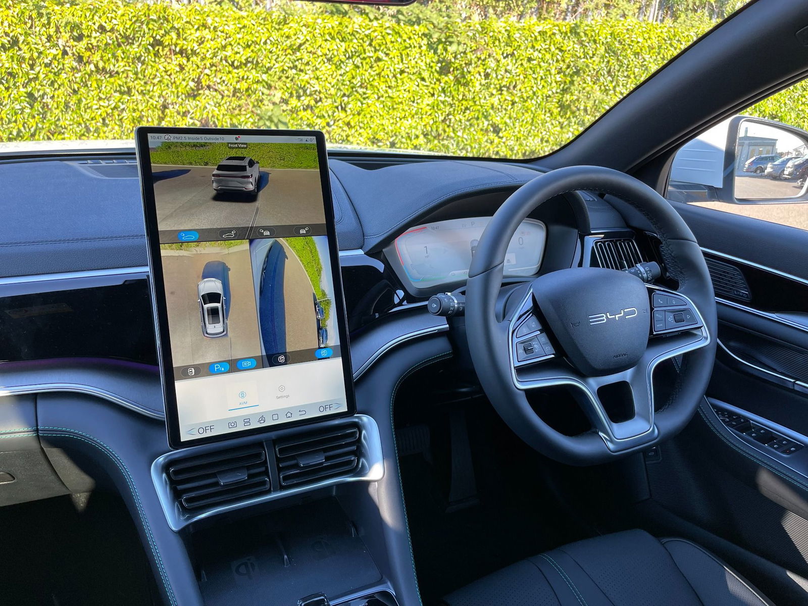 Close Up Image of Inside te BYD car with a Focus on the  BYD rotating touch screen and steering wheel