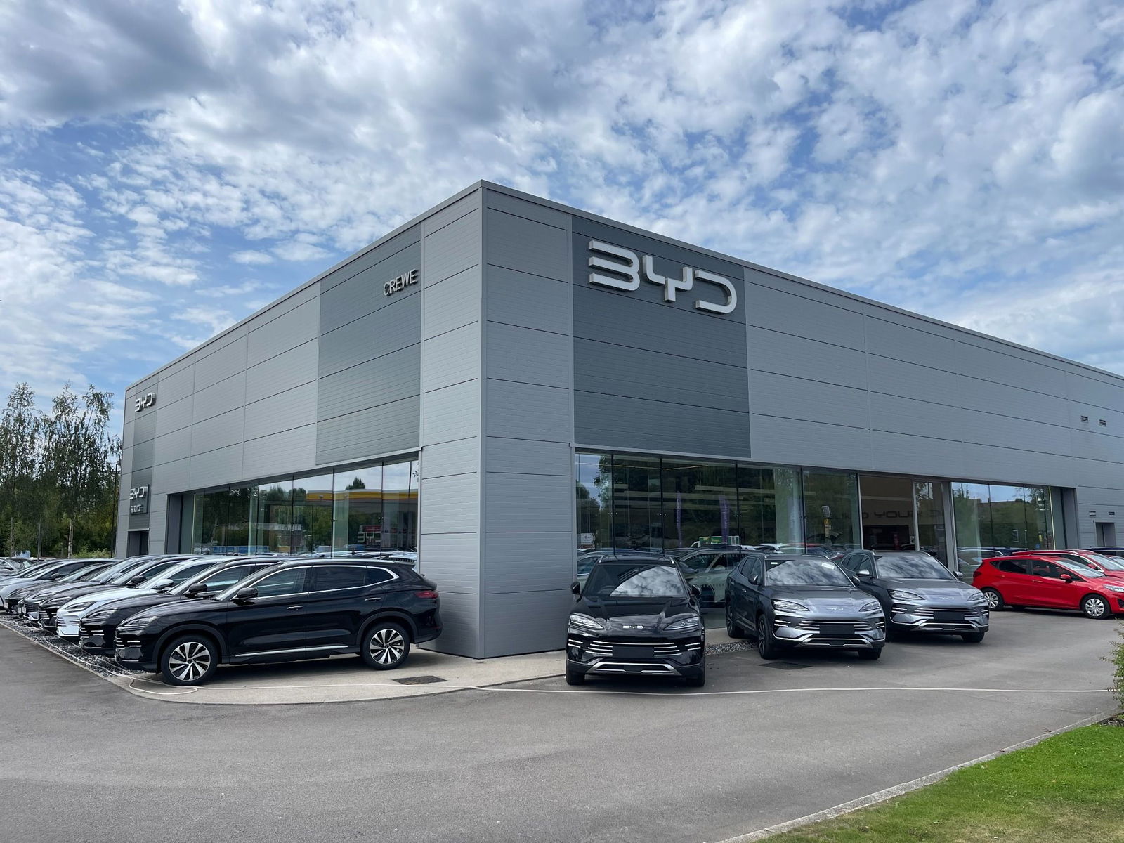 exterior of BYD Crewe with a range of different models parked around the building