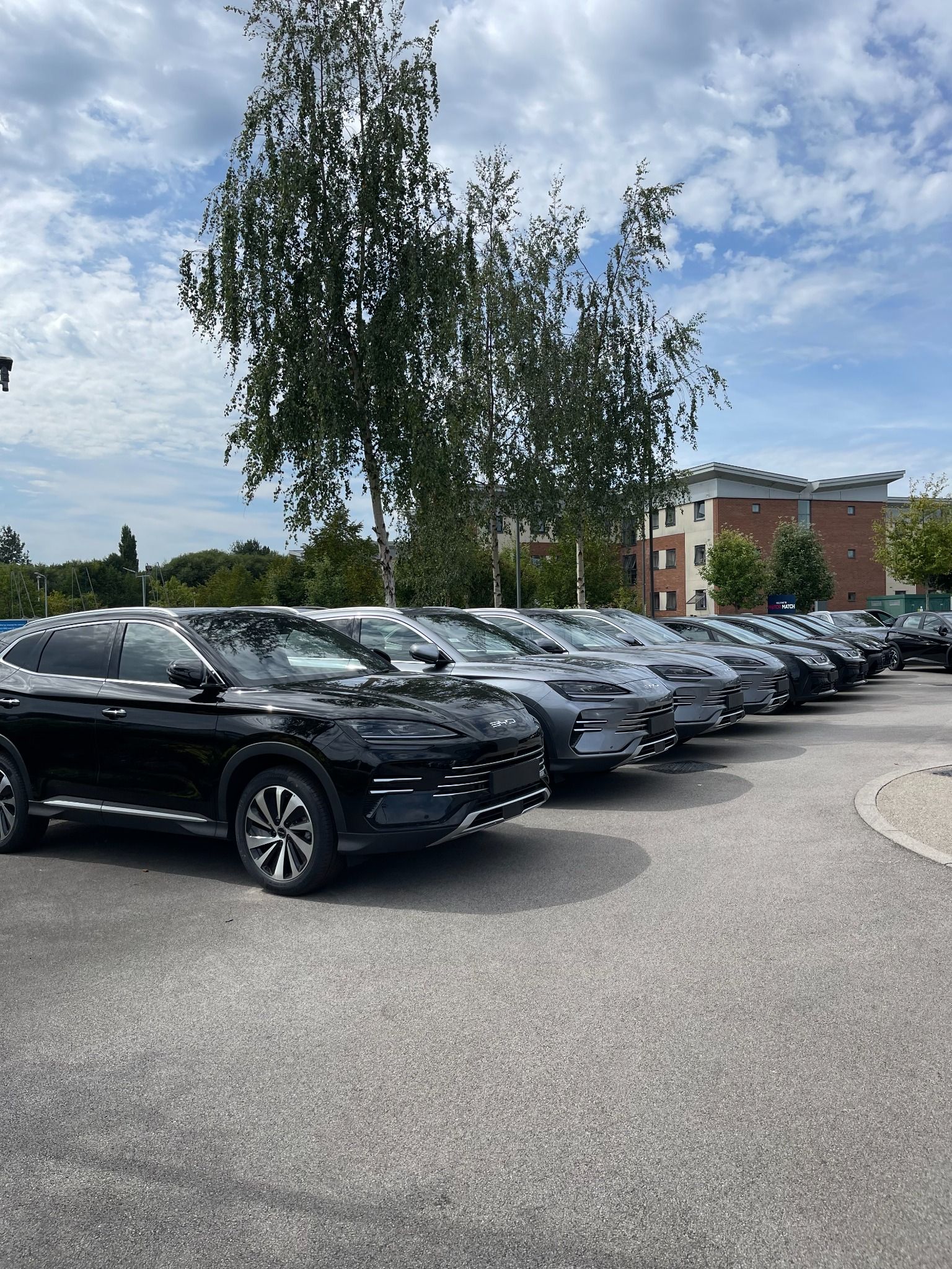 Exterior of BYD Crewe showing a line of BYD models including the BYD Dolphin, SEAL, and SEAL - U
