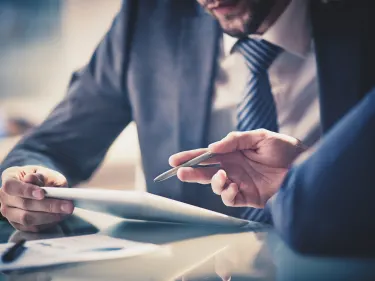 men in suits looking at a document