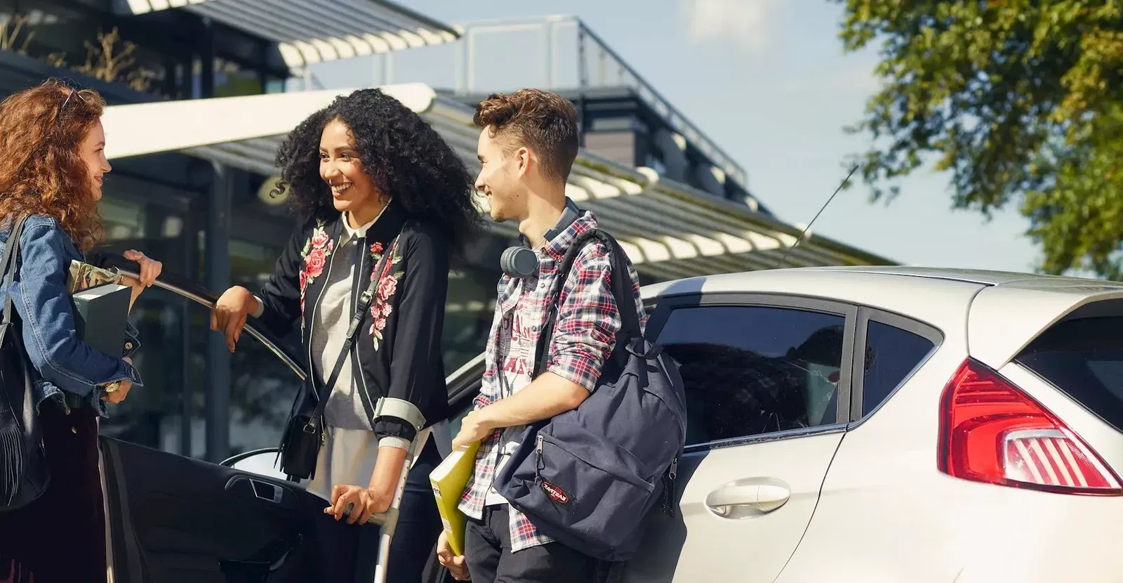 Happy woman getting out of her car and meeting friends